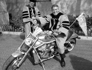 Mike Shaevitz is ready to roll on a Harley-Davidson custom VRSC, during commencement ceremonies at Columbia University. Looking on a bit warily is Jeff Bleustein, the C.E.O. of Harley-Davidson, who gave the commencement address at the school of engineering.