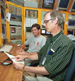 Steve Holmes and Jim Morgan examine Tevatron performance in the Main Control Room.