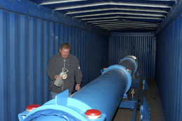 A CERN technician inspects the superconducting magnet after arrival in a container from Brookhaven.