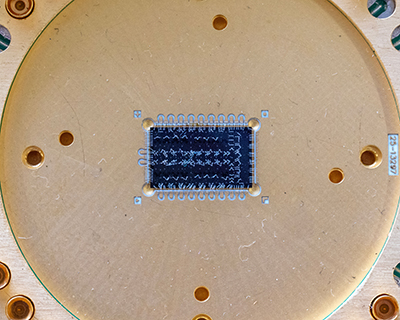 A macro photo of a chip on display in the Quantum Garage at SQMS